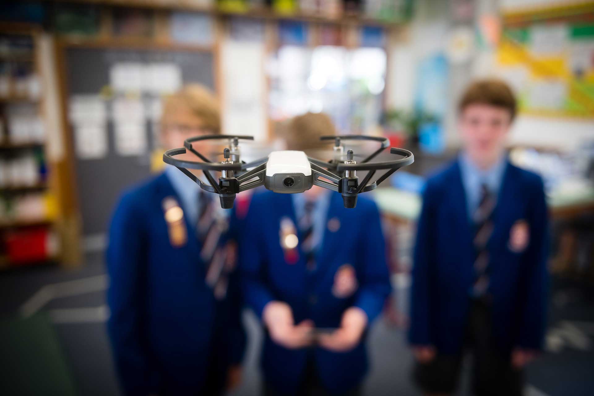 Student in the STEM room flying a drone