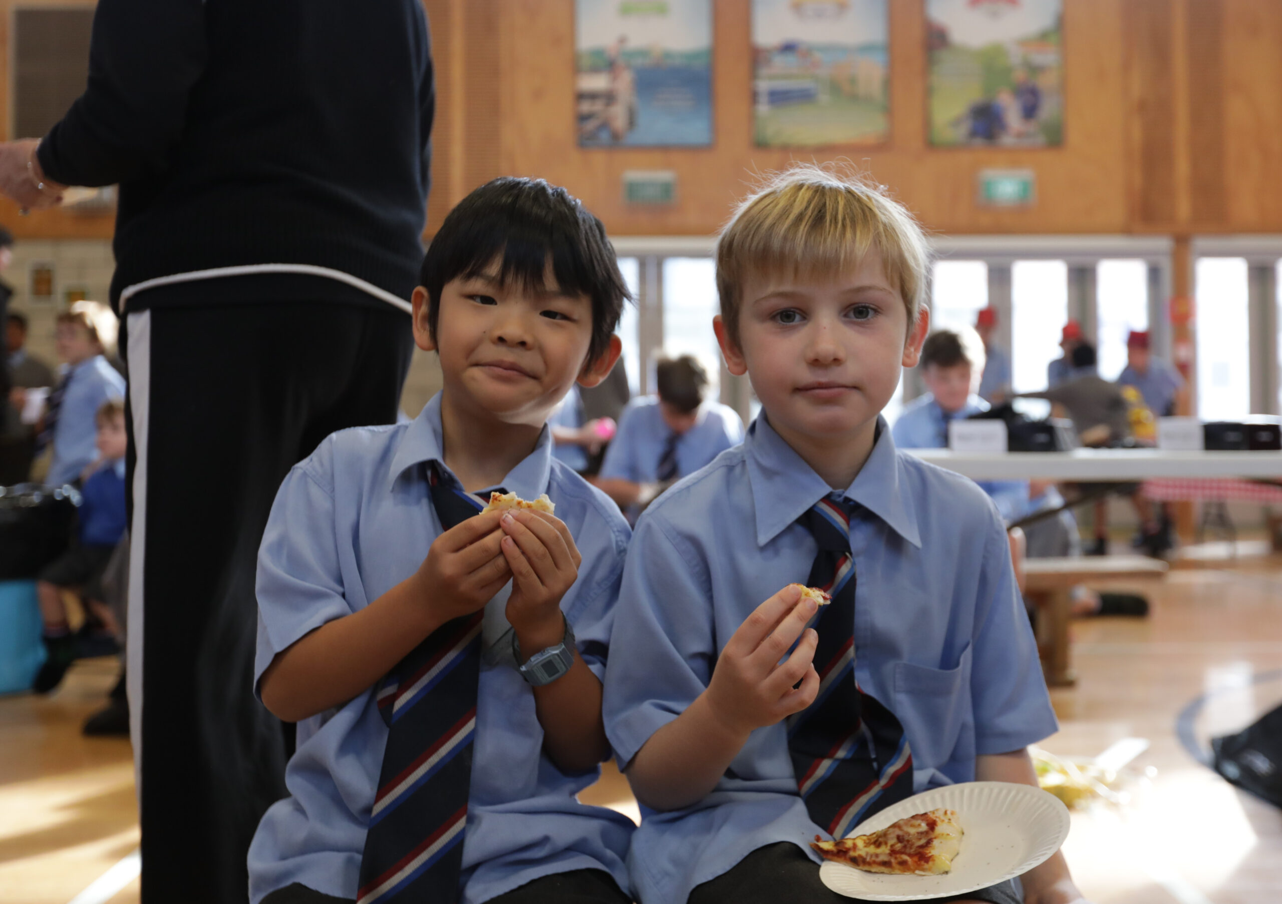 Two students in school uniforms eating in Wellesley College Hall