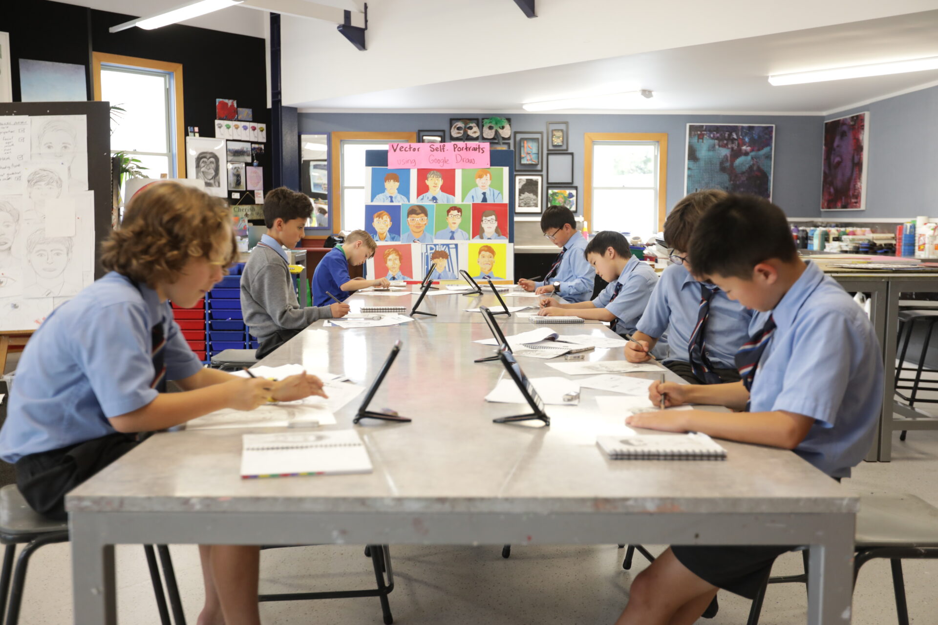 Students at Wellesley College in the art room drawing, focused on creating and designing their artwork