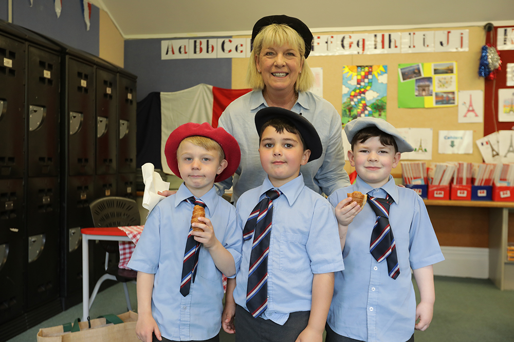 A group of students at Wellesley College learning French, focused on their lesson with books and materials on the desks