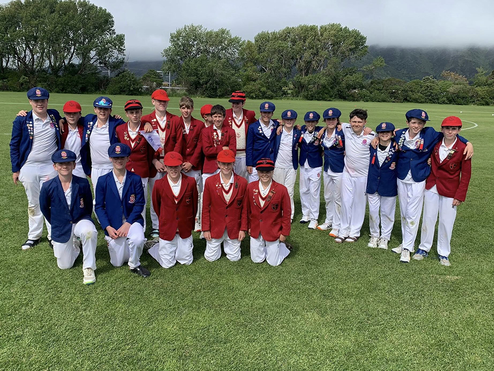 A group of boys standing together on a field after a cricket game between Wellesley College and Scots College, smiling