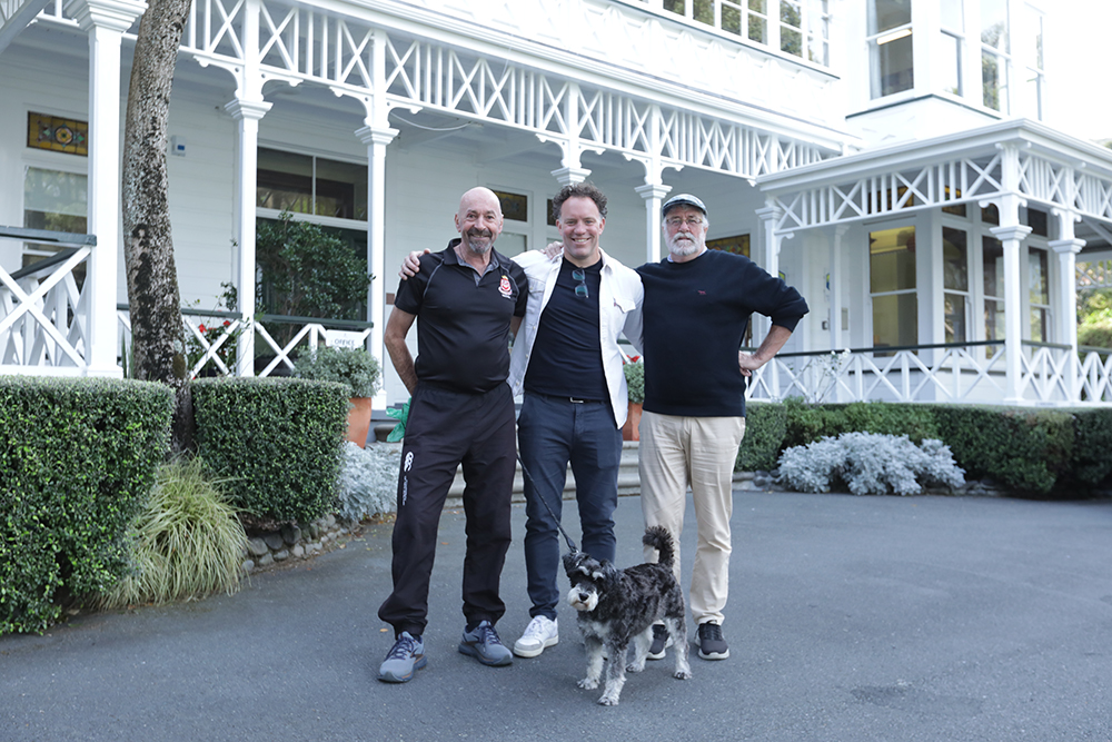 Bryn Ress and Steve Grivan standing with a Wellesley College old boy in front of Days Bay House